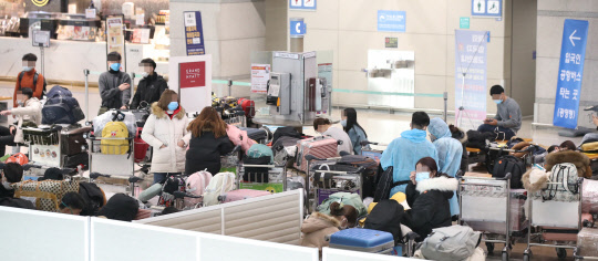 영국발 변이 코로나19 바이러스가 국내에서 확인되는 등 코로나19 확산이 계속되고 있는 28일 오전 인천국제공항 1터미널 입국장에서 베트남 입국객 등이 지정장소에서 대기하고 있다.  연합뉴스